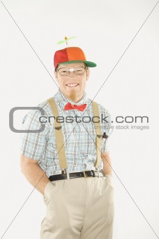 Young man dressed like nerd with hands in pockets.