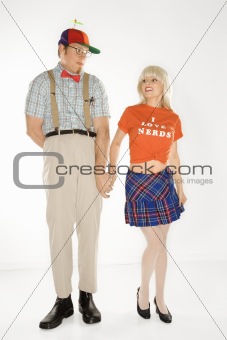 Young man dressed like nerd holding hands with  young woman.