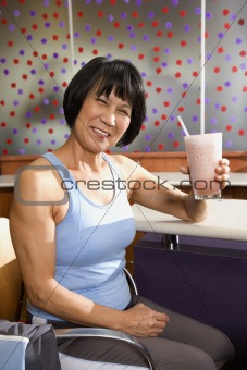 Adult female sitting at table in health club.
