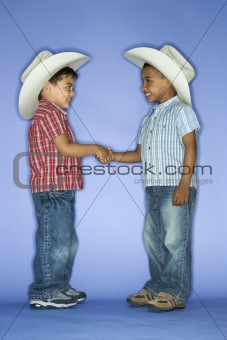 Boys in cowboy hats shaking hands.