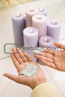 Young womans hands with facial scrub.
