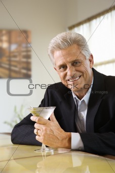 Adult male at bar with martini.