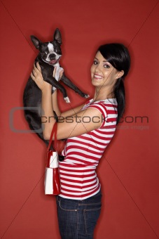 Young Caucasian woman holding Boston Terrier dog.