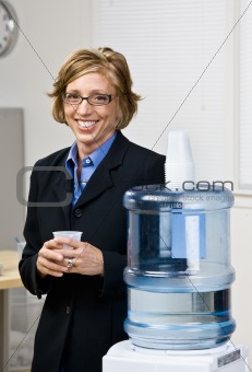 Businesswoman getting water from water cooler