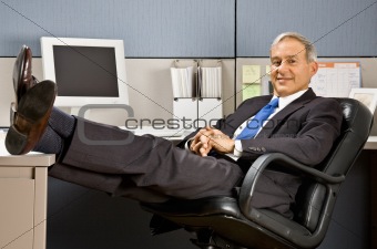 Businessman with feet up at desk