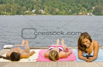 Friends laying on pier at lake