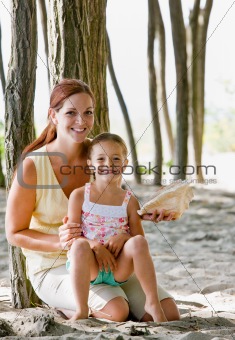 Mother and daughter with seashell