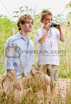 Father and son using binoculars