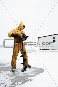 Man Drilling Hole in Ice