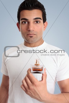 A man holds a bottle of cologne