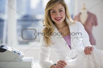 store employee holding clothes behind register