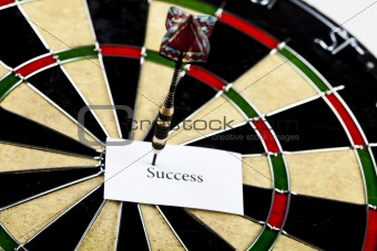 Dartboard with three darts in a bulls eye