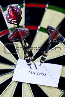 Cut image of dart pierced on target over dartboard