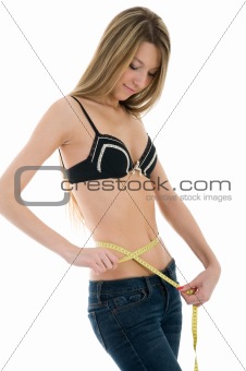 Beautiful girl measuring her waist