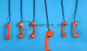 Orange telephones over blue background