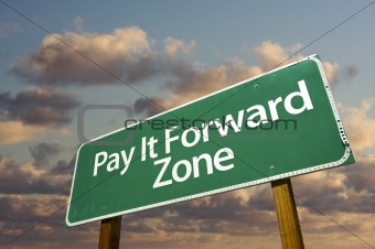 Pay It Forward Zone Green Road Sign In Front of Dramatic Clouds and Sky.