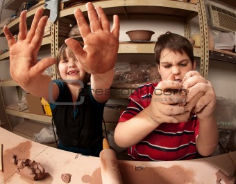 Kids with messy hands in clay studio