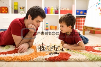 Man teaching boy the rules of chess