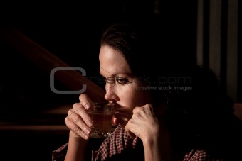 Alcoholic woman with glass of clear liquor