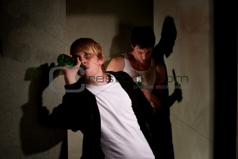 Drunk young men in hallway with bottles