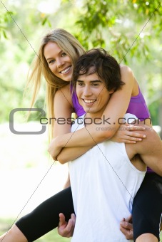 Man Giving Piggyback Ride to Woman in Park
