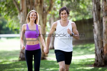 Active Young Couple Holding Hands in Park