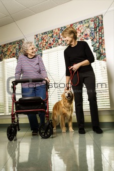 Elderly woman with middle-aged woman walking dog.