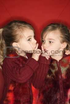 Female children twins with fingers up to lips.