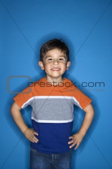 Male boy standing with hands on hips.