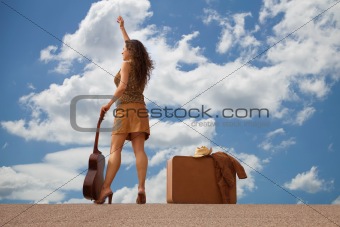 Pretty woman with suitcase and guitar