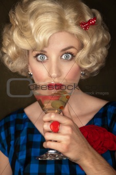 Pretty retro blonde woman in vintage 50s dress with martini
