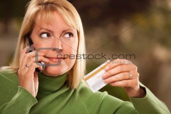 Cheerful Smiling Woman Using Her Phone with Credit Card in Hand.