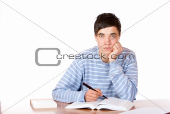 Young handsome male student sitting on desk learning for exam