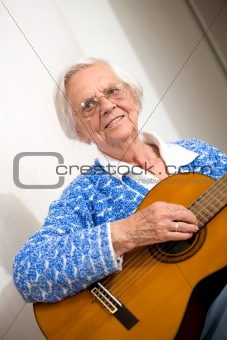 Elder woman playing guitar.