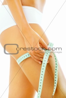 Slim tanned woman measuring her body
