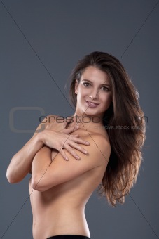 studio portrait of semi-nude brunette with long hair - isolated on gray 