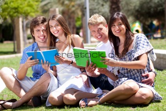 Smiling young couple holding books posing to camera