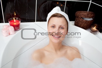 Positive woman relaxing in a bubble bath