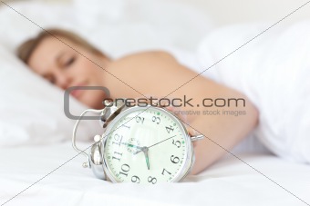 Young woman holding an alarm clock