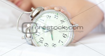 Close-up of a woman holding an alarm clock 