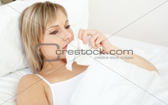 Upset sick woman blowing lying on her bed 