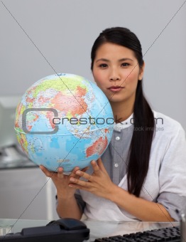 Charming asian businesswoman holding a globe