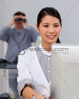 Self-assured asian businesswoman at a computer