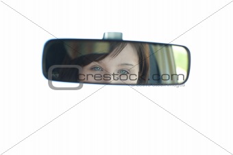 Young woman looking in the rear-view mirror