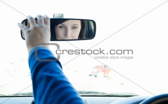 Caucasian woman looking in the rear-view mirror