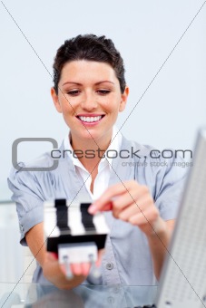 Brunette businesswoman consulting a business card holder