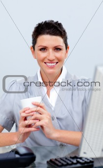 Positive business woman drinking coffee