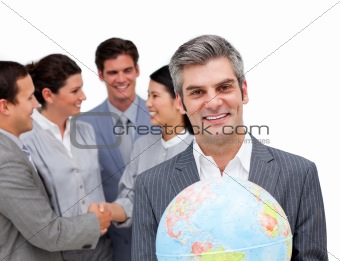 Mature manager holding a terrestrial globe in front of his team