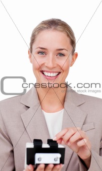 Smiling businesswoman consulting a business card holder 