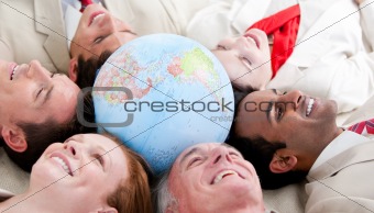 Multi-ethnic business people lying around a globe